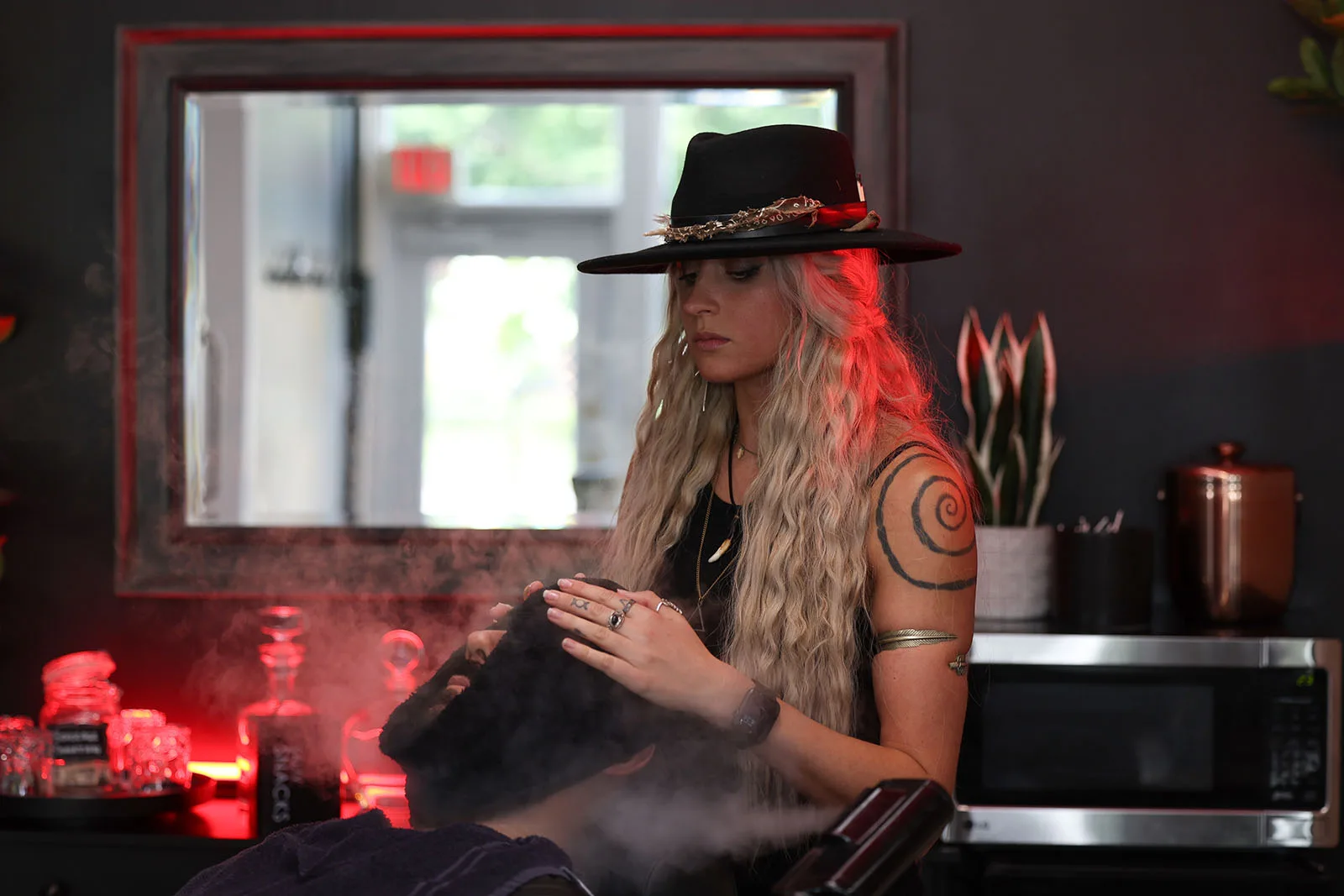 Hot towel wrapped around a client's face during a straight-razor shave at Black Hat Barber